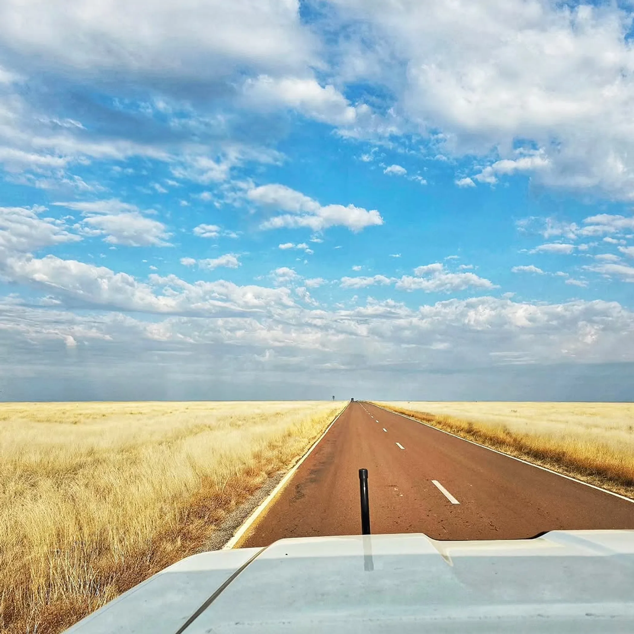 remote straight road through spinifex plains